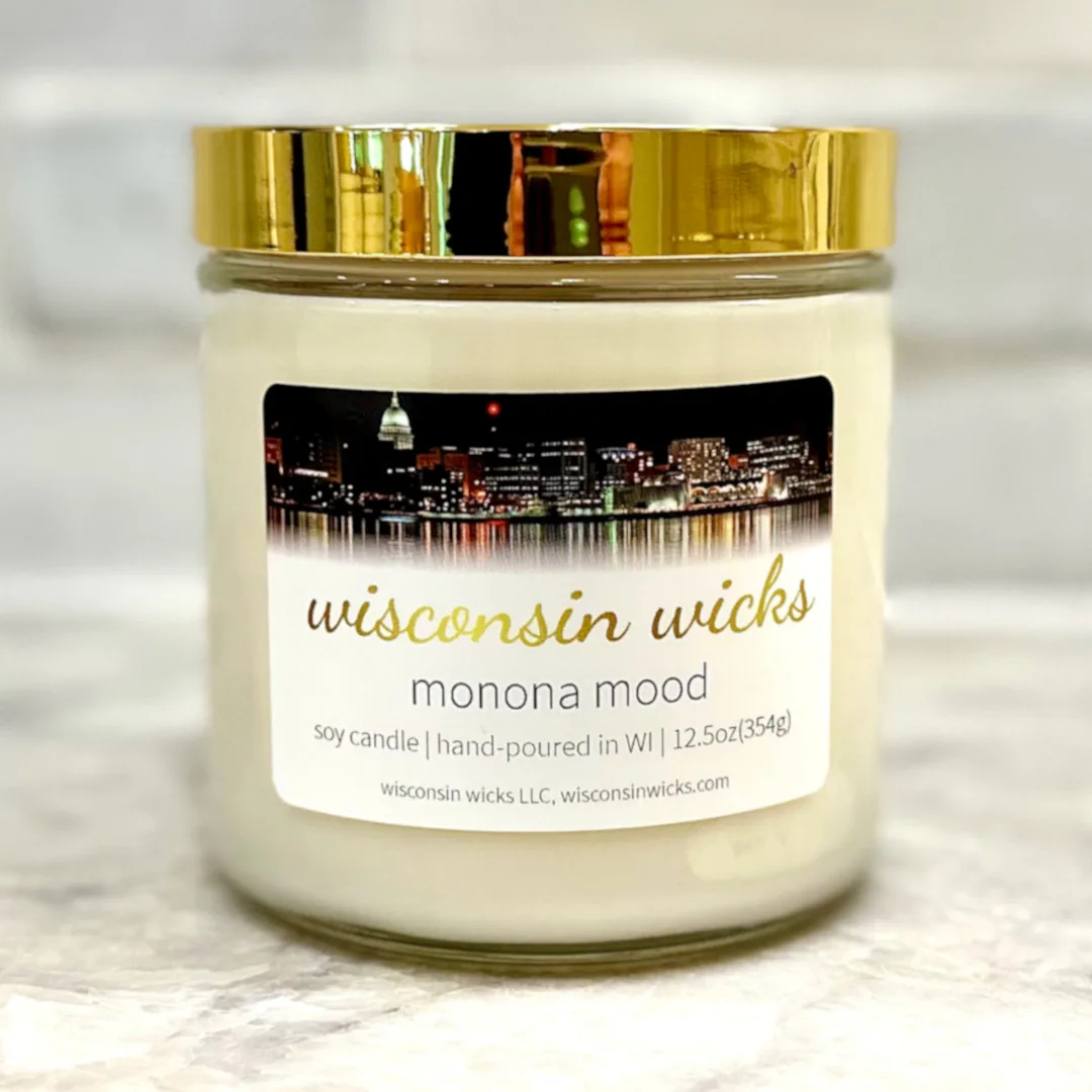 Luxurious gold candle adorned with a label featuring visuals of Madison, Wisconsin at night displayed on marble countertop